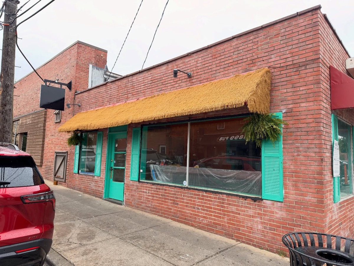 Acosta's storefront: brick building with a thatched awning and teal door